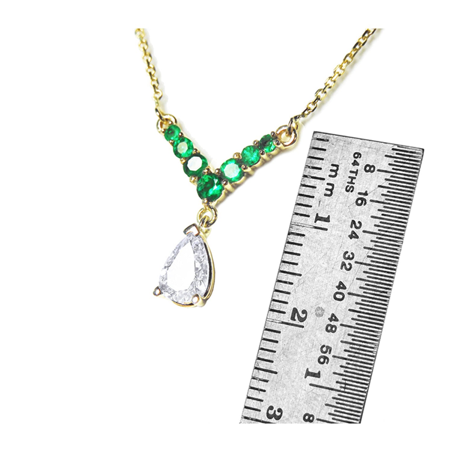 14K gold necklace with pear-cut diamond and seven round emeralds, shown with ruler for scale.