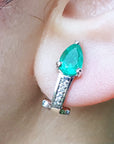 Close-up of a teardrop emerald earring on an ear. gift for Mother's Day