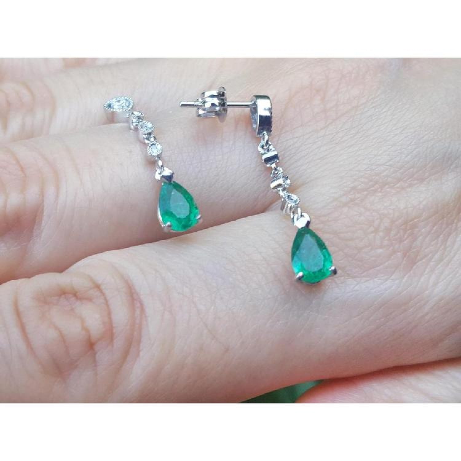 14K white gold pear-shaped emerald drop earrings with brilliant white diamond accents.