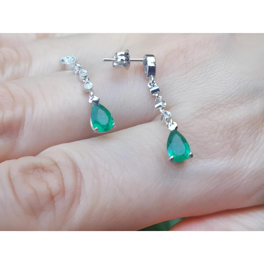 14K white gold pear-shaped emerald drop earrings with brilliant white diamond accents.