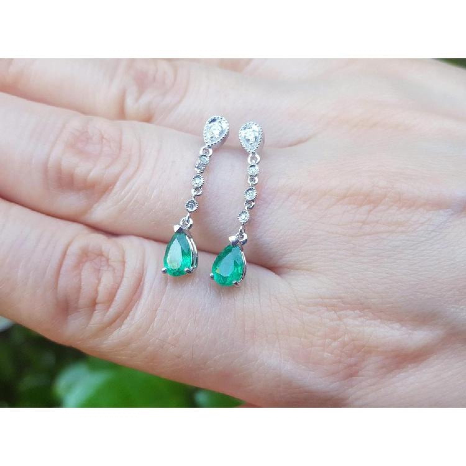 1.05 ct. pear-shaped emerald drop earrings in 14K white gold with diamond accents.