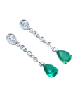 A pair of pear shaped natural colombian emerald drop earrings accent diamonds crafted in 14k white gold.
