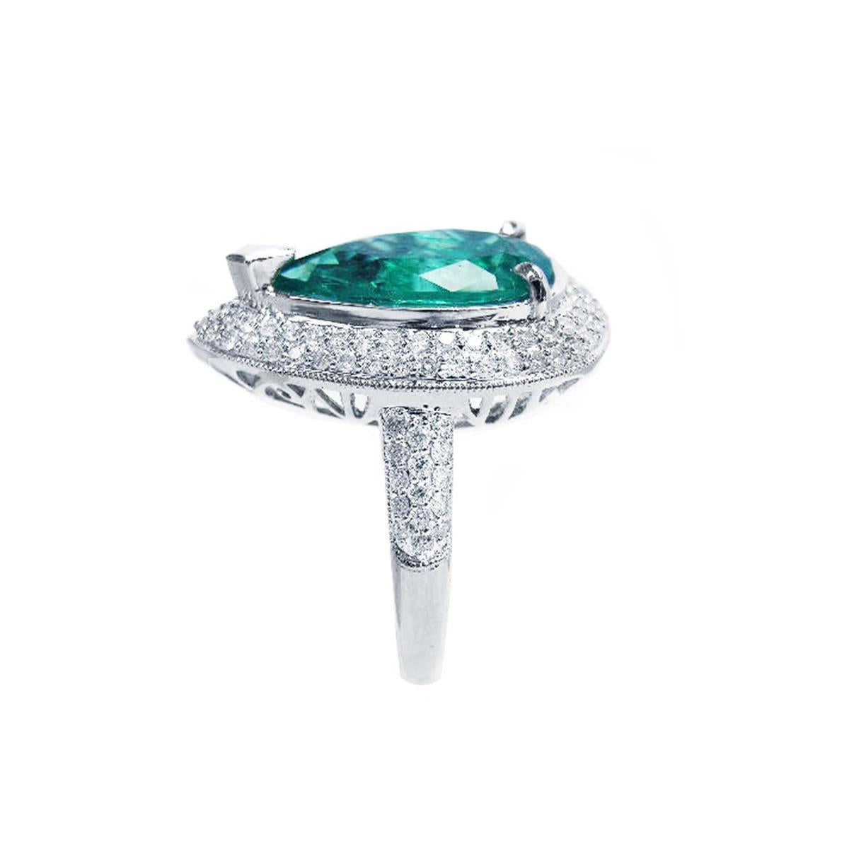 A pear shaped emerald and double halo diamond ring, in side profile position.