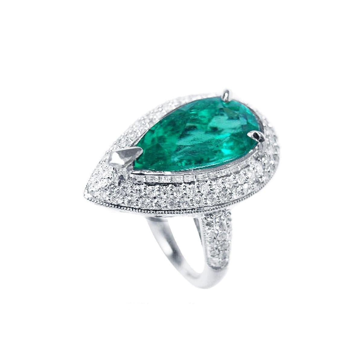 A top left view of a white gold emerald engagement ring pear shaped
