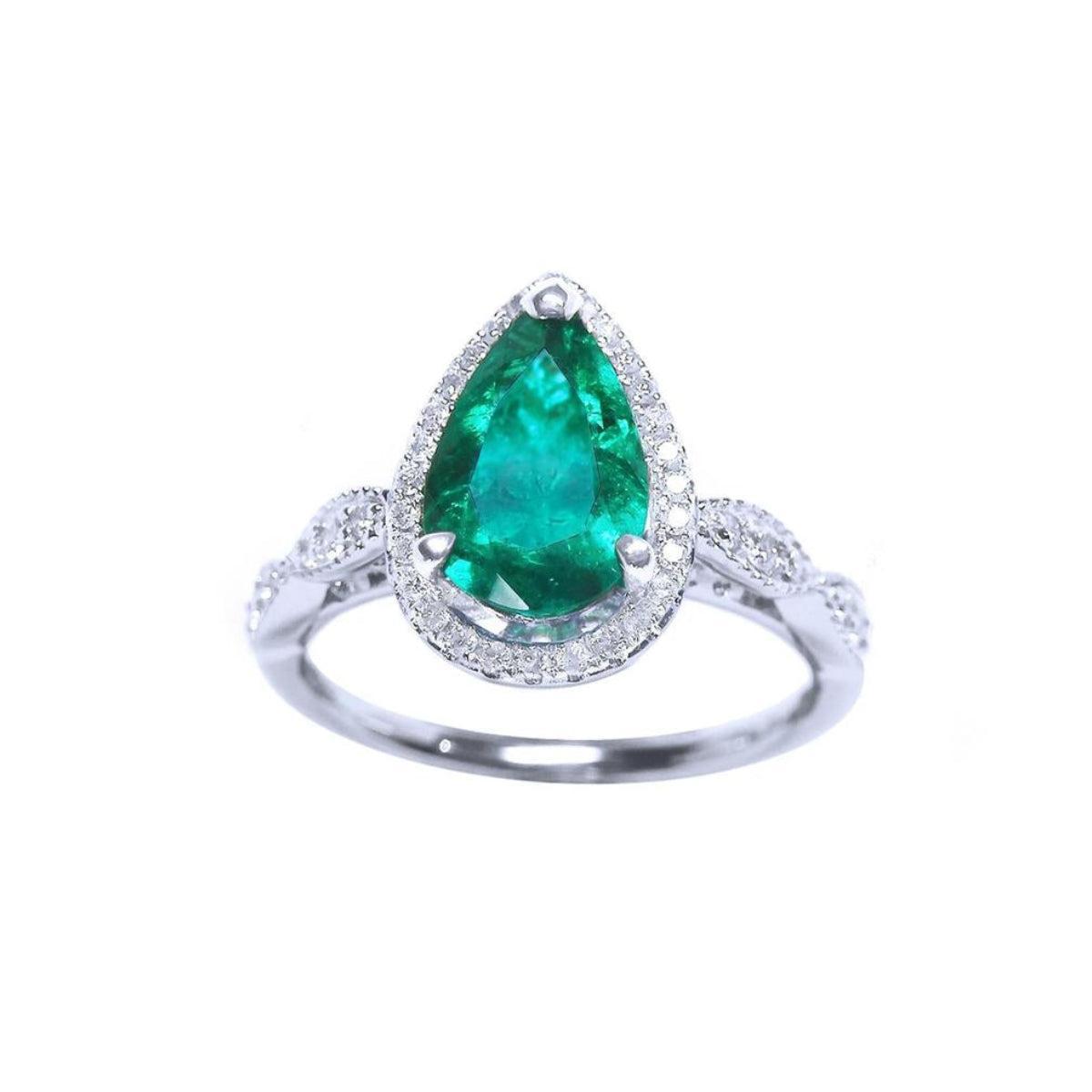 A teardrop emerald with halo diamond in white gold on a front position, topside view.