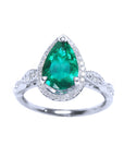 A teardrop emerald with halo diamond in white gold on a front position, topside view.