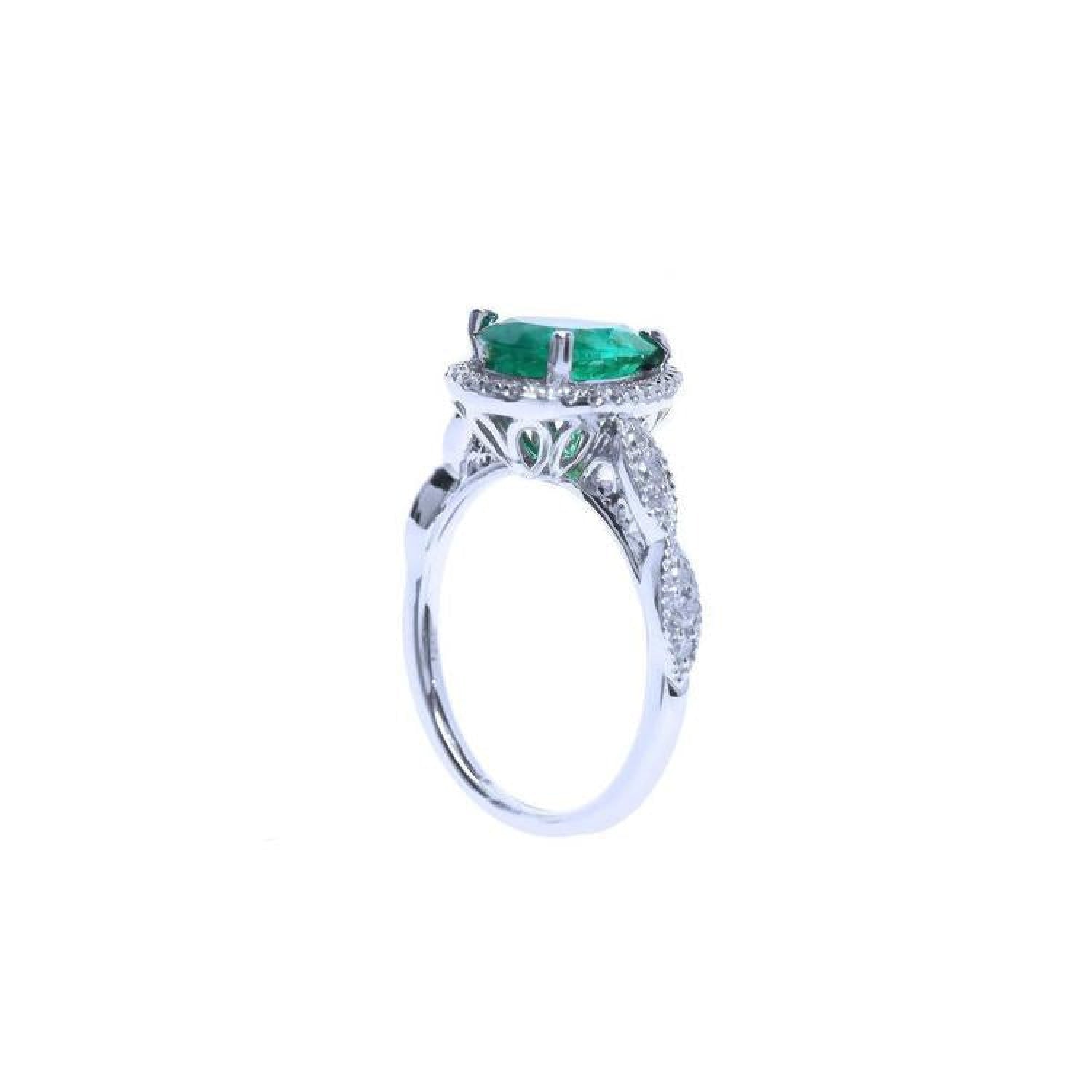 1.43 ct teardrop emerald engagement ring in 14K white gold with diamond halo and twisted band.