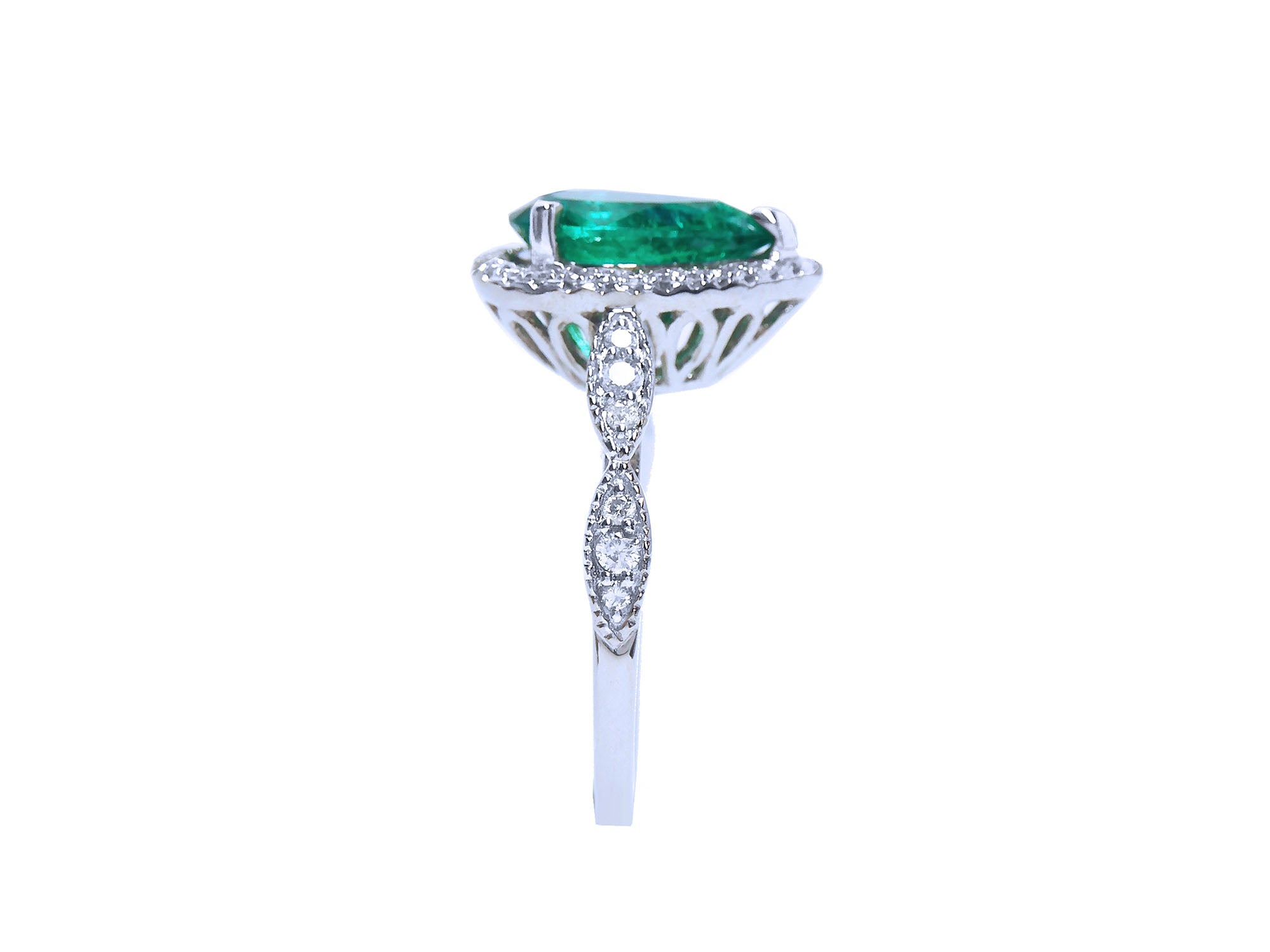 A white gold ring with a teardrop emerald and diamond-studded band on a white background.
