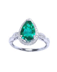 A teardrop natural colombian emerald surrounded by a halo of natural diamonds and made of 14k white gold.