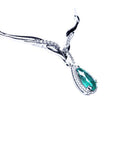 A 14k white gold women's emerald necklace pear cut encircled by a halo natural diamond.