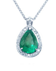 Emerald teardrop pendant with diamond halo on a topside view.