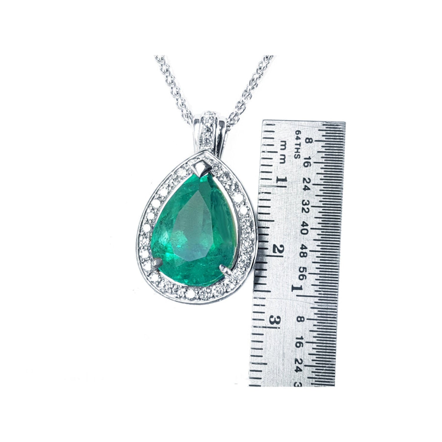 8.64 ct. pear-shaped emerald pendant with halo diamonds in 14K white gold, shown next to a metal ruler for scale.