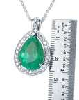 Emerald pendant with white gold chain next to a ruler for size reference