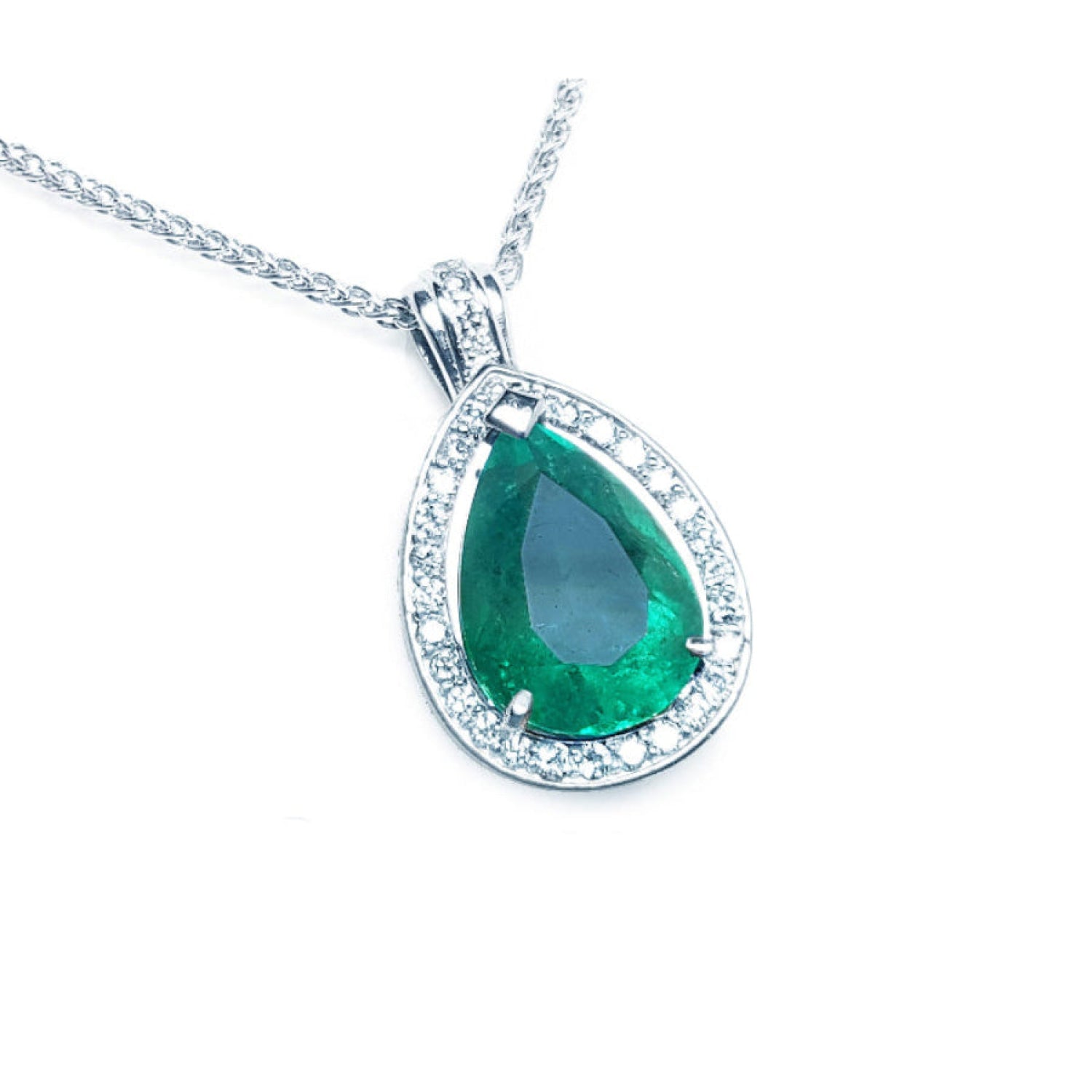 Teardrop-shaped natural colombian emerald pendant with halo diamond accents made of 14k white gold.