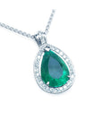 Teardrop-shaped natural colombian emerald pendant with halo diamond accents made of 14k white gold.