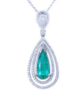 Teardrop-shaped emerald pendant with double halo diamond accents on a white background topside view.