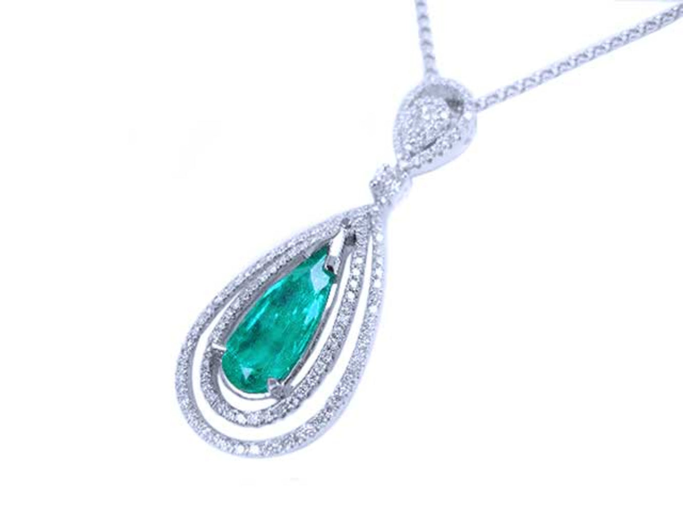 Double halo diamond pendant with a natural emerald gemstone on a white background