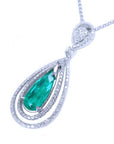 Double halo diamond pendant with a natural emerald gemstone on a white background