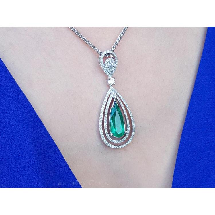 Emerald pendant necklace on a person wearing a blue dress