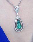 Emerald pendant necklace on a person wearing a blue dress