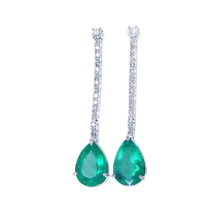 Pair of emerald teardrop earrings with diamonds accents on a white background