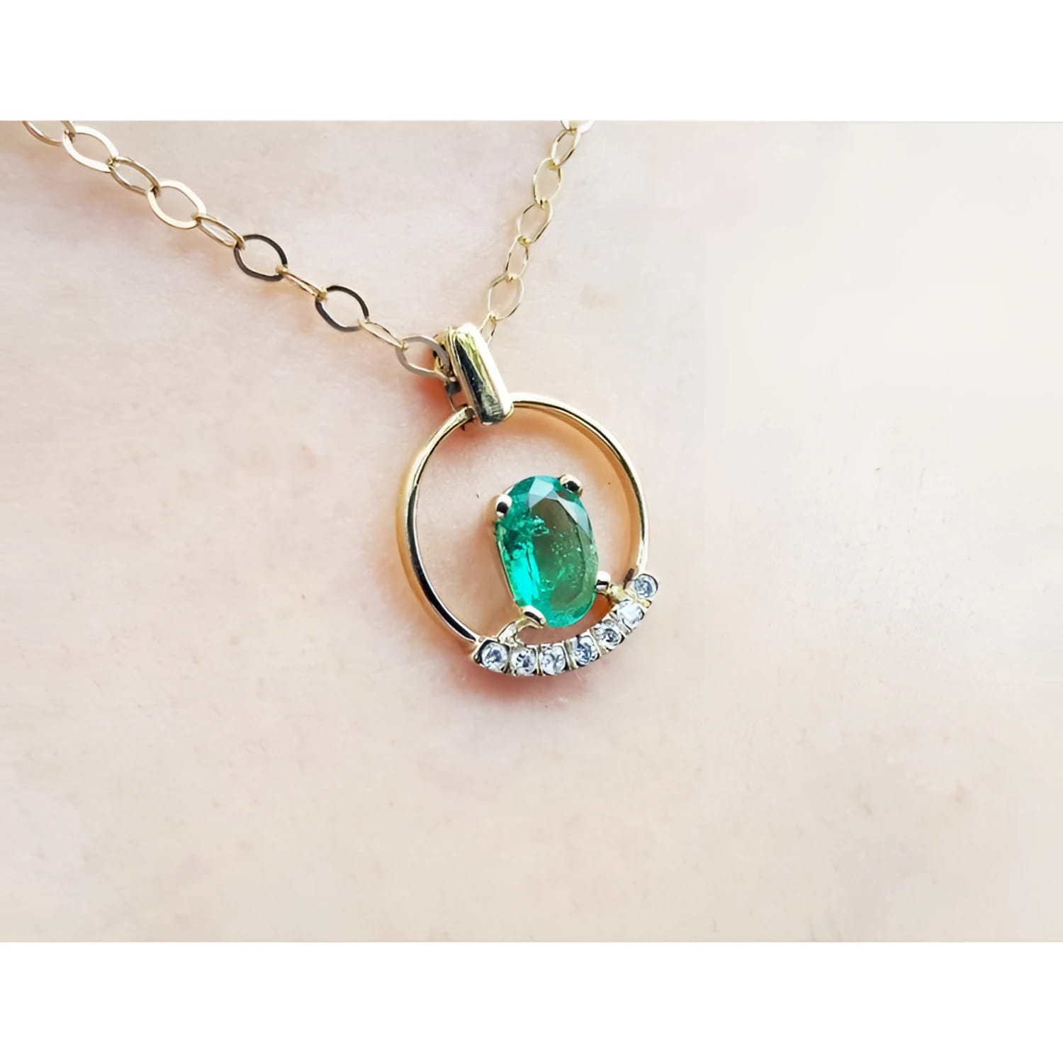 14k yellow gold necklace with oval natural Colombian emerald and diamond accents.