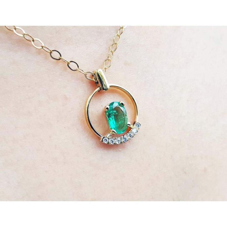 14k yellow gold necklace with oval natural Colombian emerald and diamond accents.