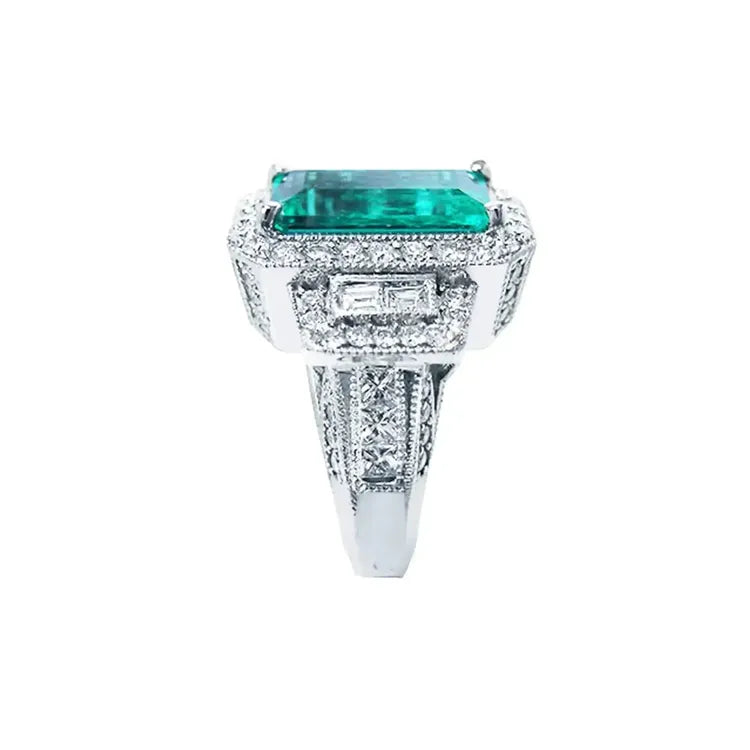 Anillo de compromiso 18k con esmeralda colombiana rectangular de 2.99 ct. verde medio, rodeada de diamantes.