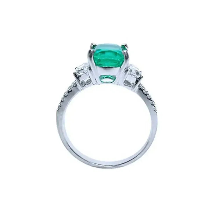Vista lateral de anillo con esmeralda corte cojín y diamantes en oro blanco para bodas