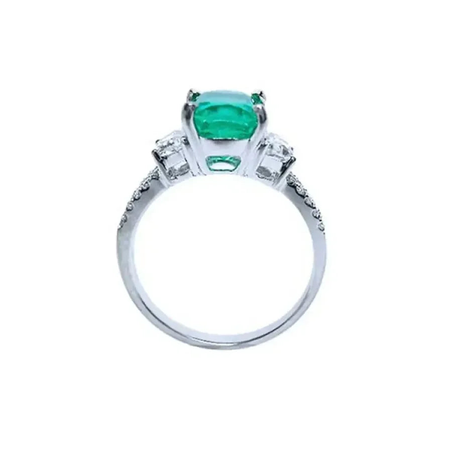Anillo de compromiso de oro blanco 18k con esmeralda colombiana central y diamantes trapezoide y pavé.