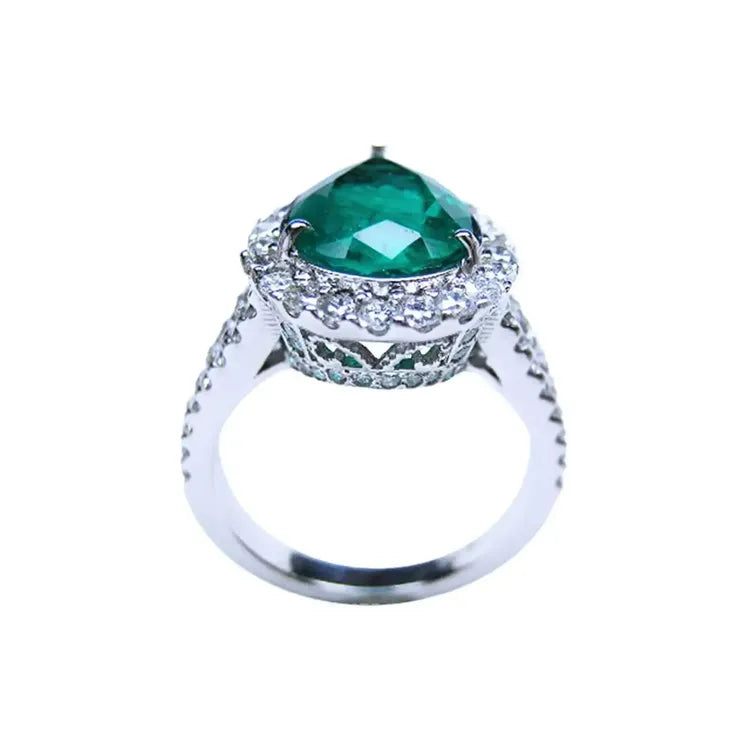 Anillo de oro blanco 18k con esmeralda colombiana corte pera de 4.02 ct y halo de diamantes.