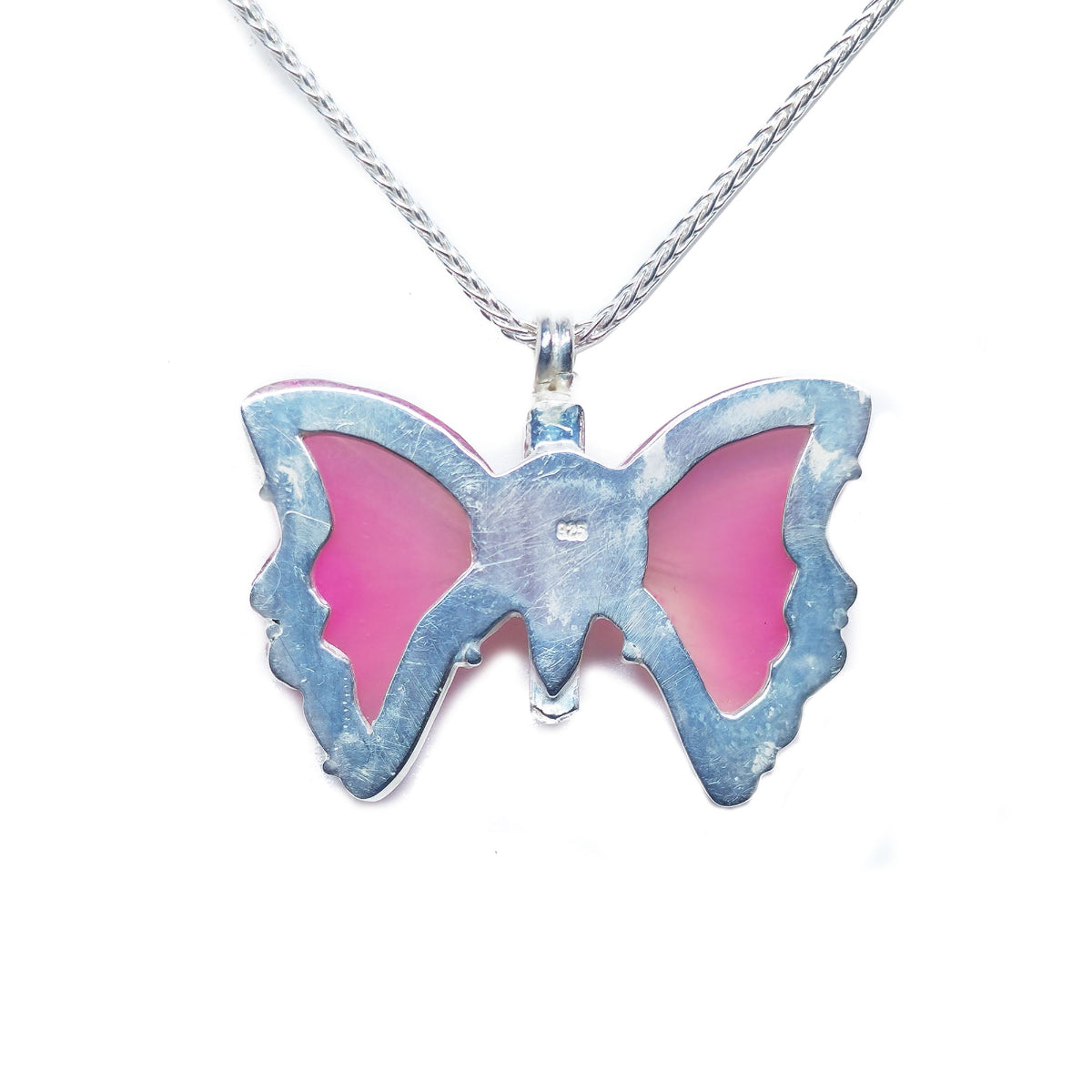 Butterfly-shaped pendant with pink agate interior and silver outline on a white background