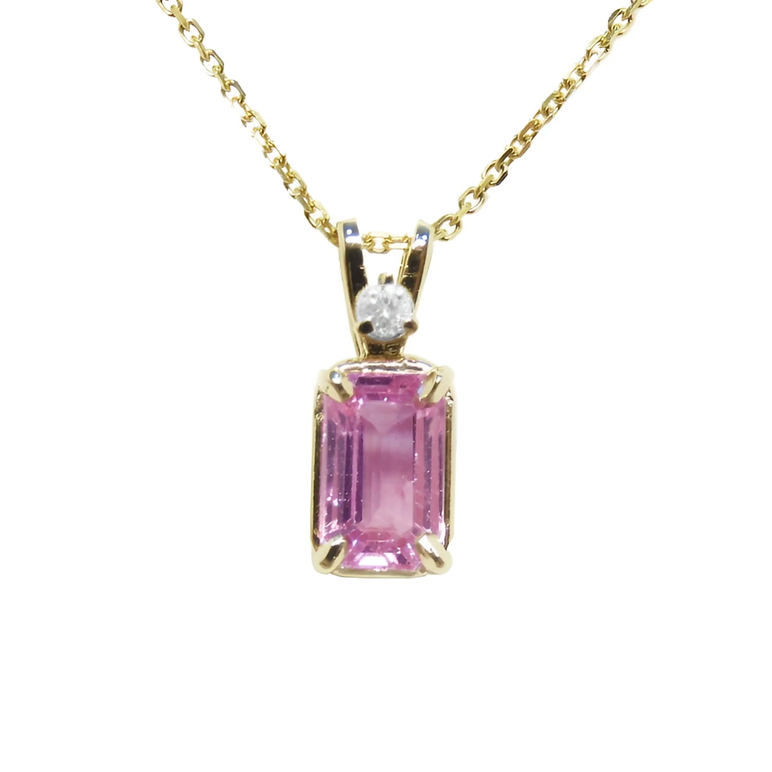 A genuine emerald-cut pink sapphire pendant necklace, featuring an accent natural diamond in a prong setting, crafted in 14k yellow gold.