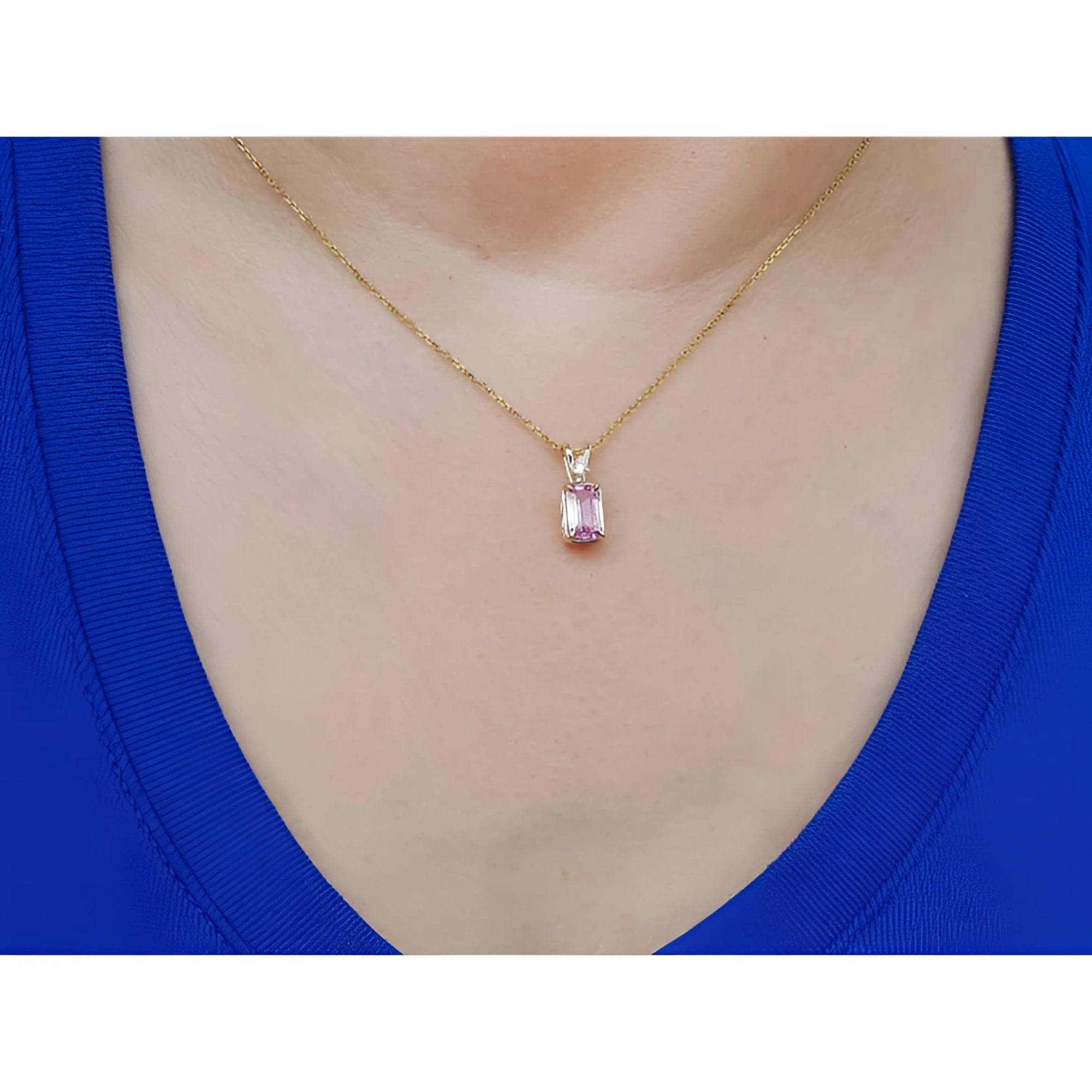 14k gold necklace with a pink genuine sapphire pendant worn by a person in a blue top.