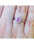 hand wearing a natural pink sapphire ring for women halo diamond in 14k white gold, 