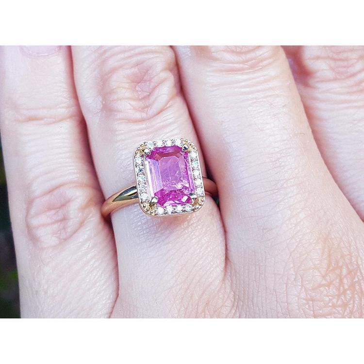 Pink sapphire ring for women emerald-cut halo diamonds 14k yellow gold, o a woman's hand