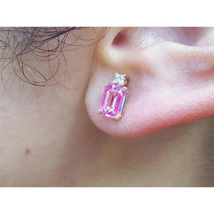 Close-up of a pink sapphire stud earring worn on an ear