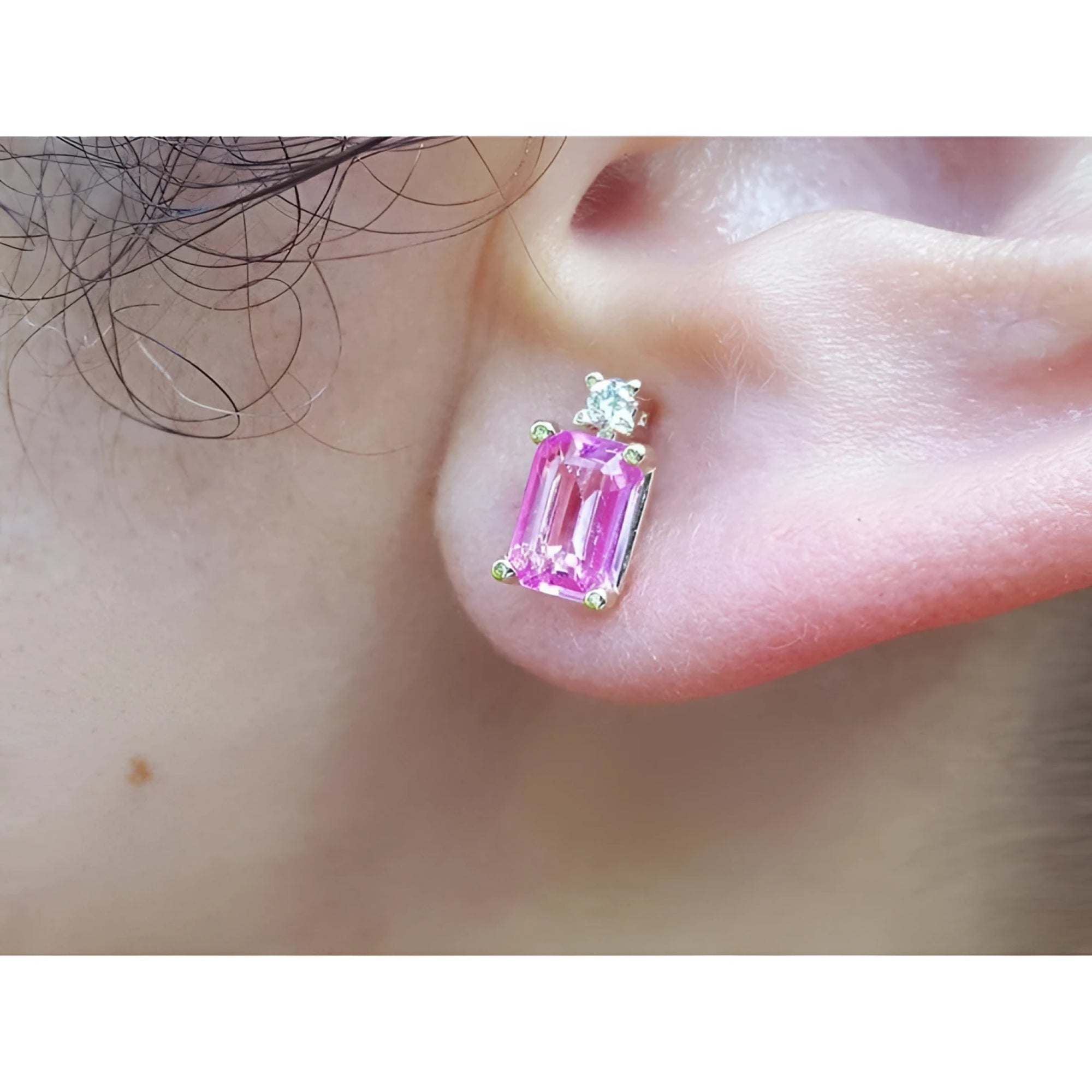 Genuine Pink sapphire stud earrings rectangular emerald cut medium pink color, very brilliant, natural diamonds on top, worn on an ear.