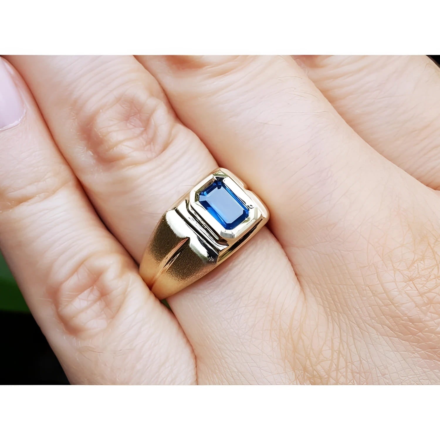 Men's 14k yellow gold pinky ring with a rectangular, medium dark blue sapphire, bezel set.