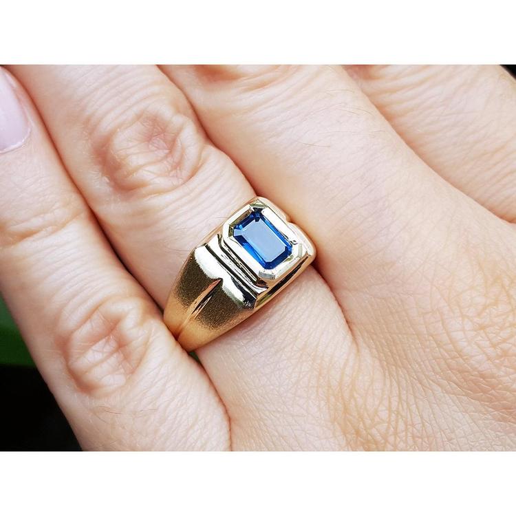 Gold ring with a blue natural sapphire gemstone on a hand