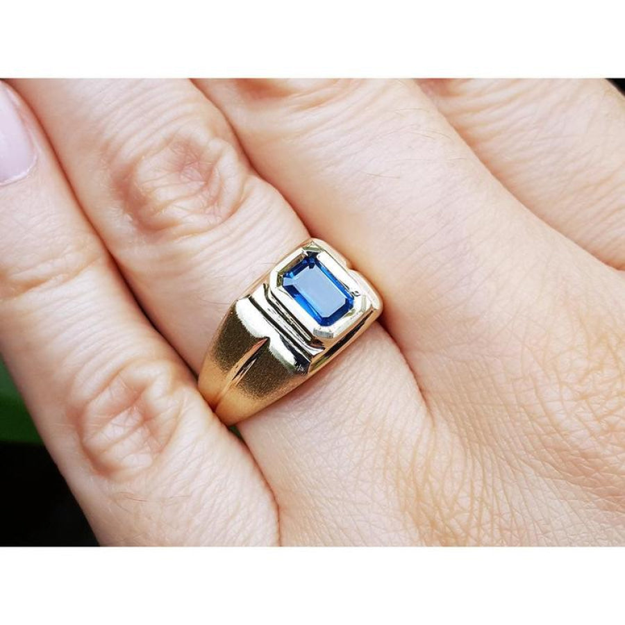 Men's 14k yellow gold pinky ring with a rectangular, medium dark blue sapphire, bezel set.