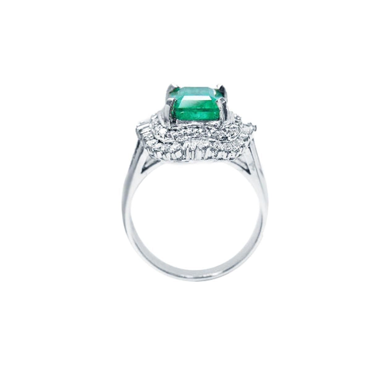 Ring with a natural emerald and diamond accents on a lateral profile view.