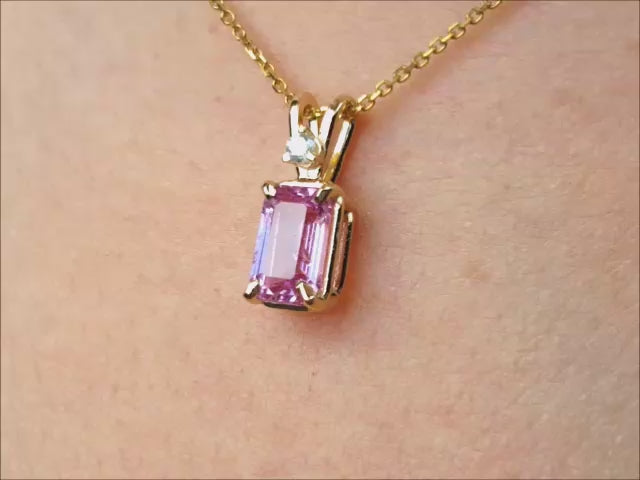 Natural pink sapphire and diamond pendant necklace crafted in 14k yellow gold.
