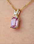 Natural pink sapphire and diamond pendant necklace crafted in 14k yellow gold.