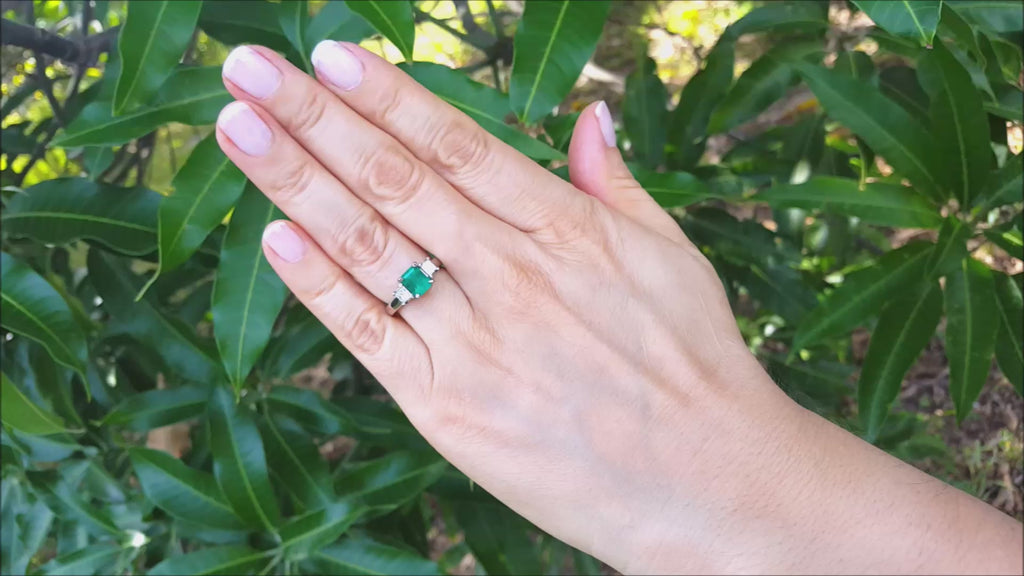 Emerald engagement ring three stone side princess cut diamonds