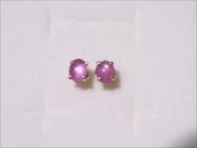 natural star pink sapphire cabochon stud earrings crafted in 14k yellow gold.