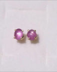 natural star pink sapphire cabochon stud earrings crafted in 14k yellow gold.