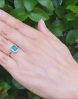 Emerald-cut and halo diamond emerald ring white gold.