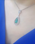 Teardrop colombian emerald and halo diamond pendant white gold.