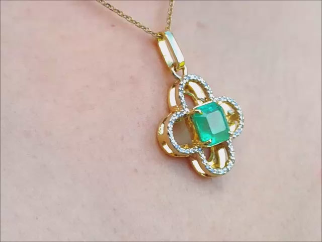 Clover design pendant with a center natural colombian emerald and halo diamonds.